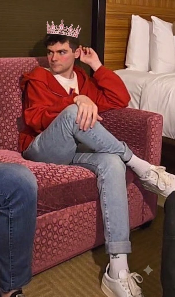 Unofficial fan edit: Nick Fuentes seated with legs crossed, pink blush and tiara added for satire